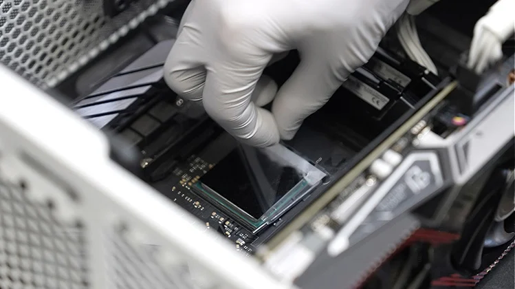 Gloved hand applying Carbice Ice pad to CPU inside of computer case