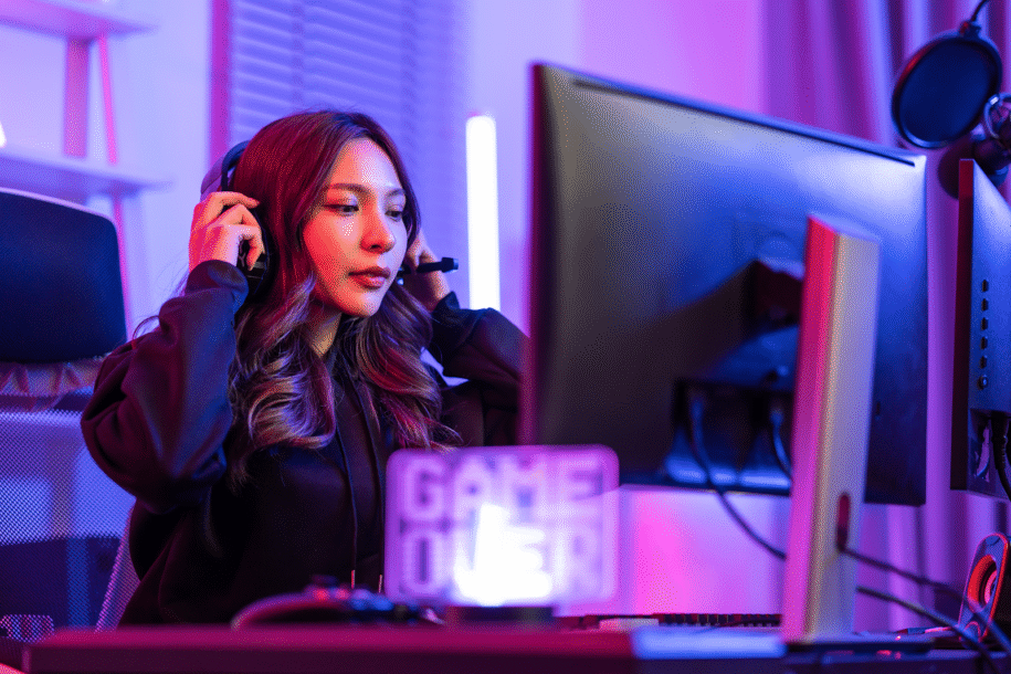 Young woman sitting at a computer desk providing support via headset.
