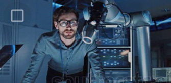 Person coding on a laptop, flanked by two monitors displaying colorful code.
