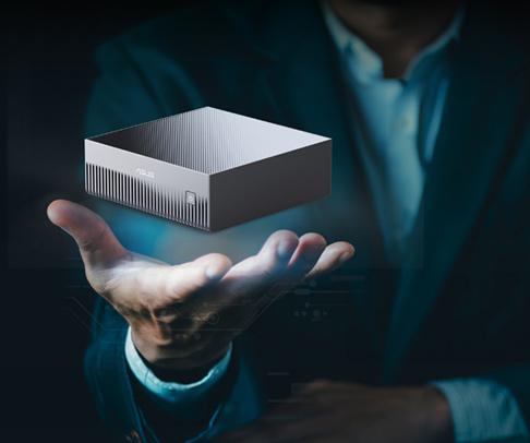 Man in suit holds a levitating, sleek ASUS mini PC in a futuristic setting.